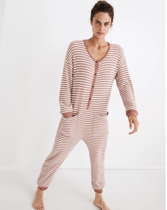 Model wearing striped pajama onesie