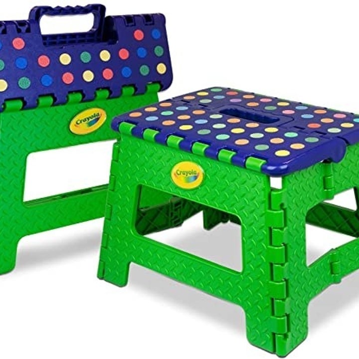 The green step stool folded up next to another stool that's not folded