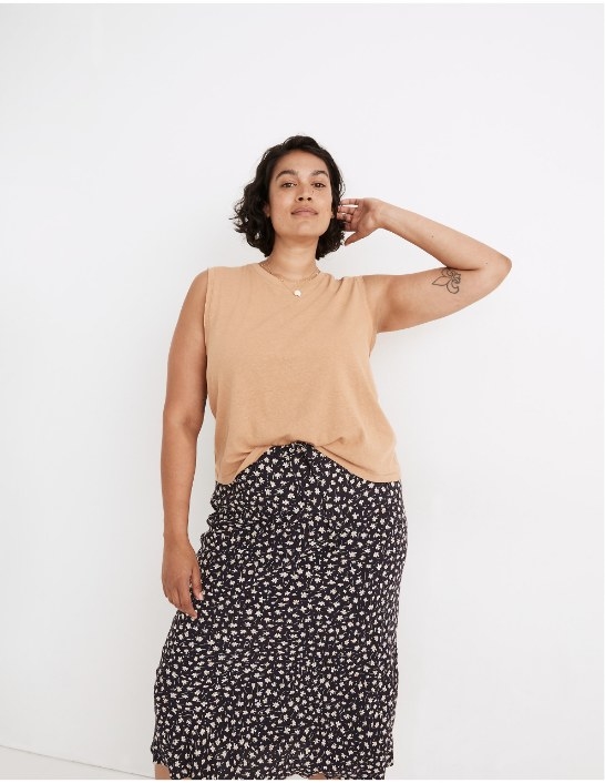 Model wearing tan colored tank with black skirt