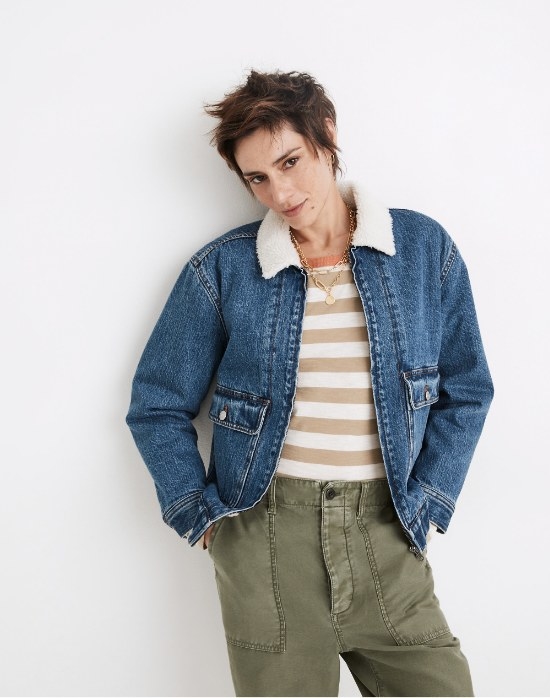 Model wearing denim jacket with striped shirt and green pants