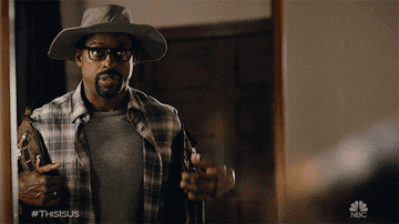 Sterling K. Brown in This Is Us wearing hiking hat, putting on a vest