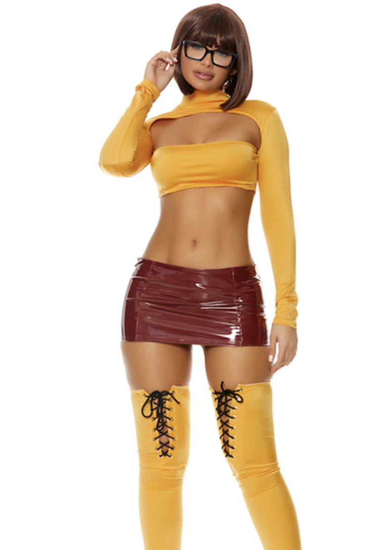 A woman wearing a brown pleather mini skirt and an orange crop top with an odd cutout to show more cleavage