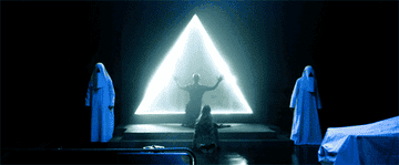 GIF of a person kneeling in front of a triangle shamed portal