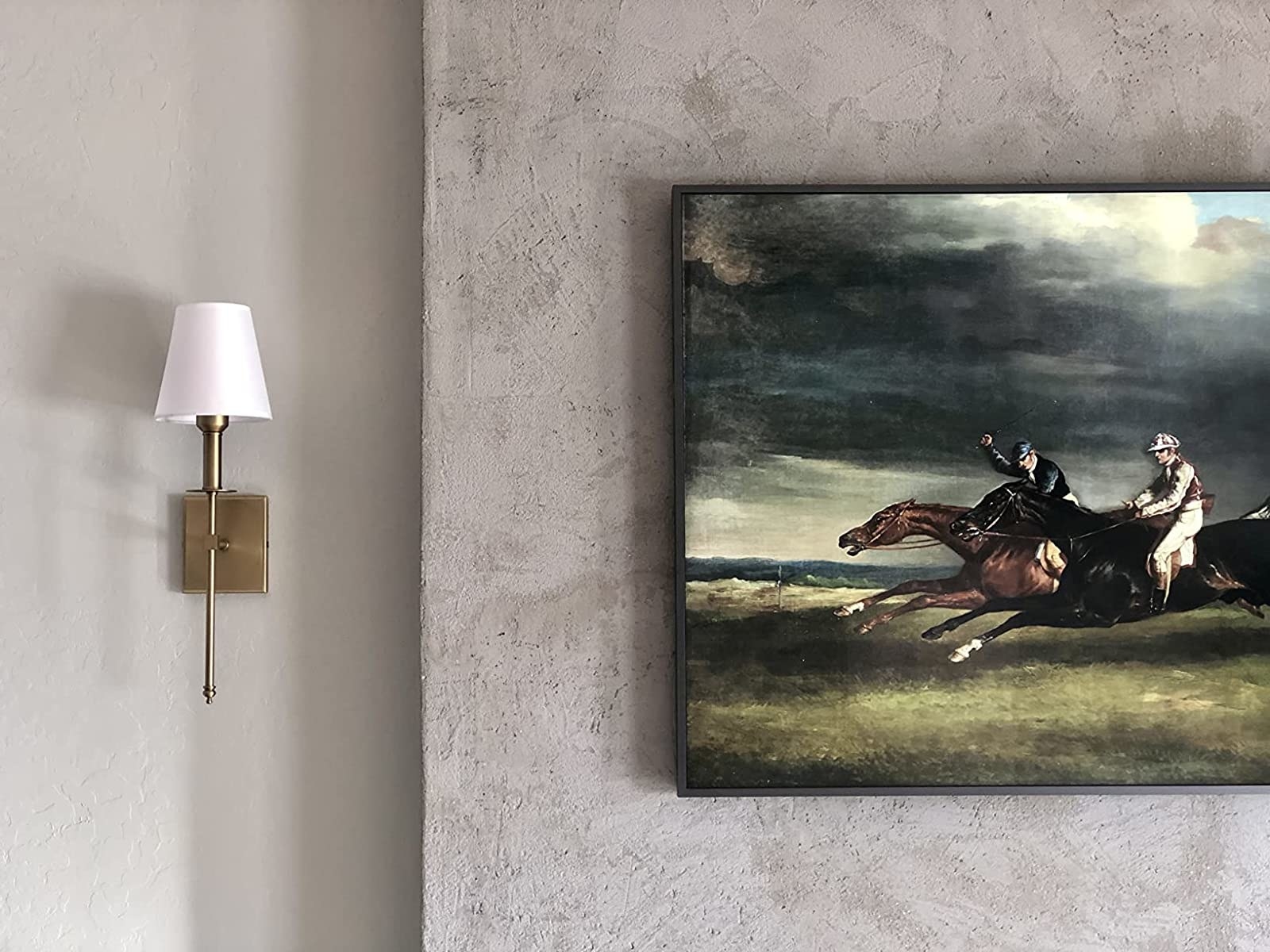 a reviewer&#x27;s brass sconce hung on a wall next to a painting