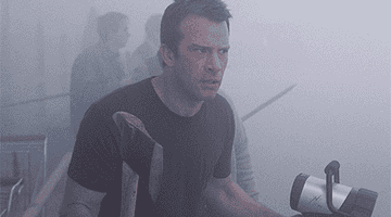 GIF of Thomas Jane holding an ax and flashlight as he walks through the mist