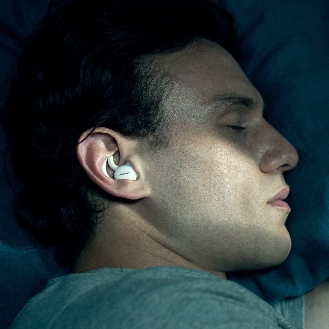 a person sleeping on their side while wearing the sleep pods in their ears