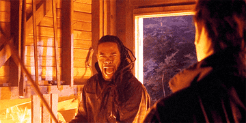 GIF of Busta Rhymes hitting Michael Myers with a shovel as the house goes up in flames