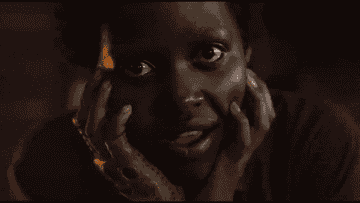 Lupita wearing a red jumpsuit