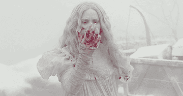 GIF of Mia Wasikowska wearing all white, hand covered in blood
