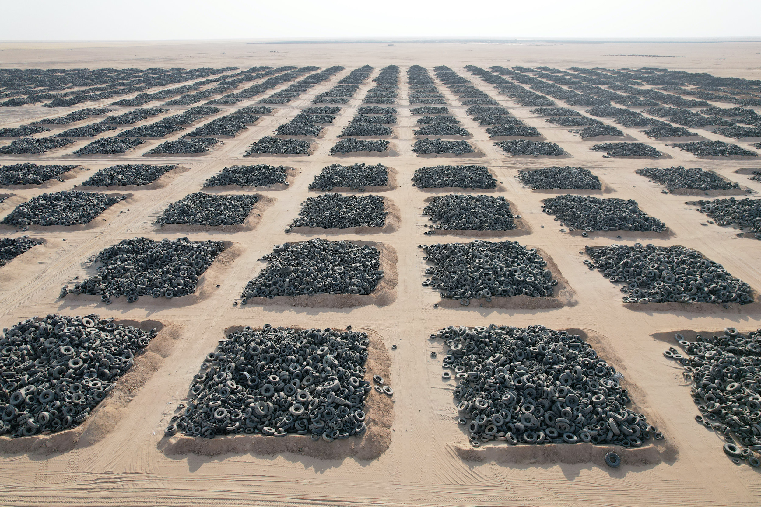 Thousands of tires sit in piles of sand in a remote area of the Middle East