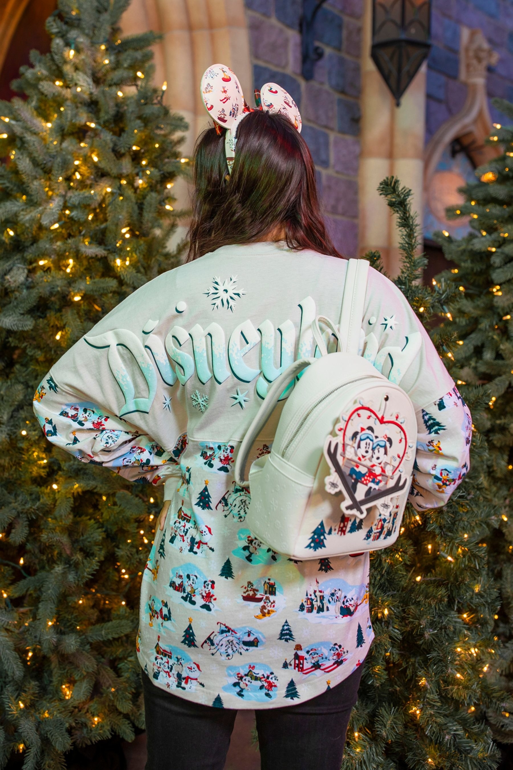 A white spirit jersey with winter scenes printed on it and a Disneyland logo across the back