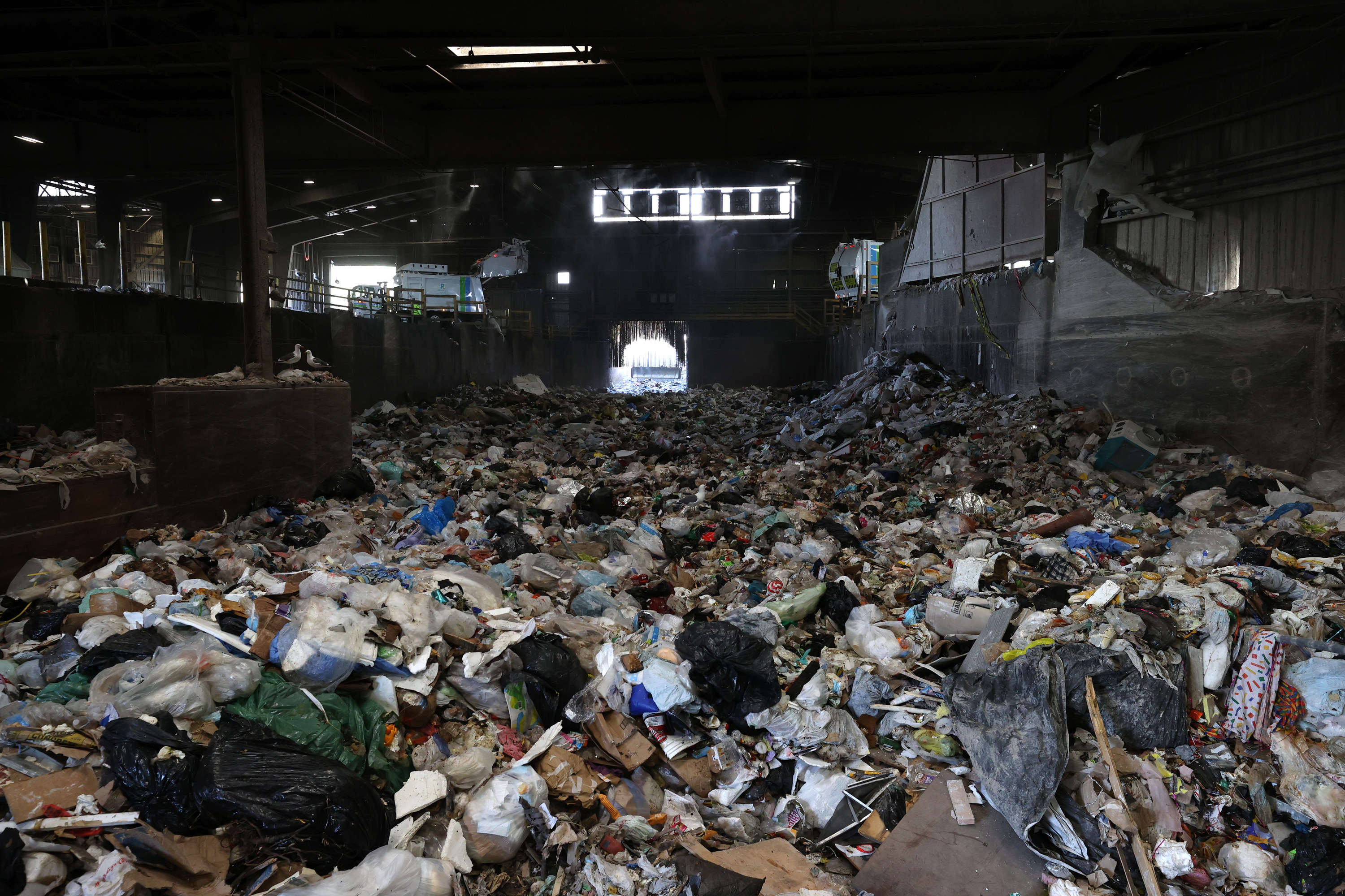 Inside a warehouse trash is seen piled up filling the space