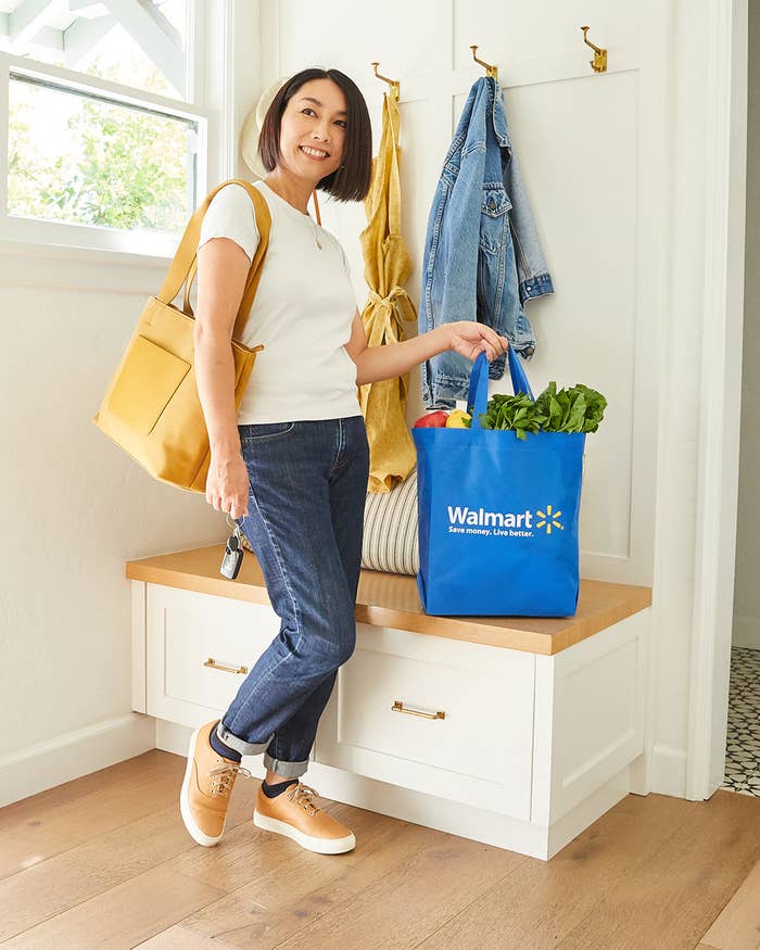Rie entering the home holding her son’s diaper bag and a Walmart bag full of ingredients