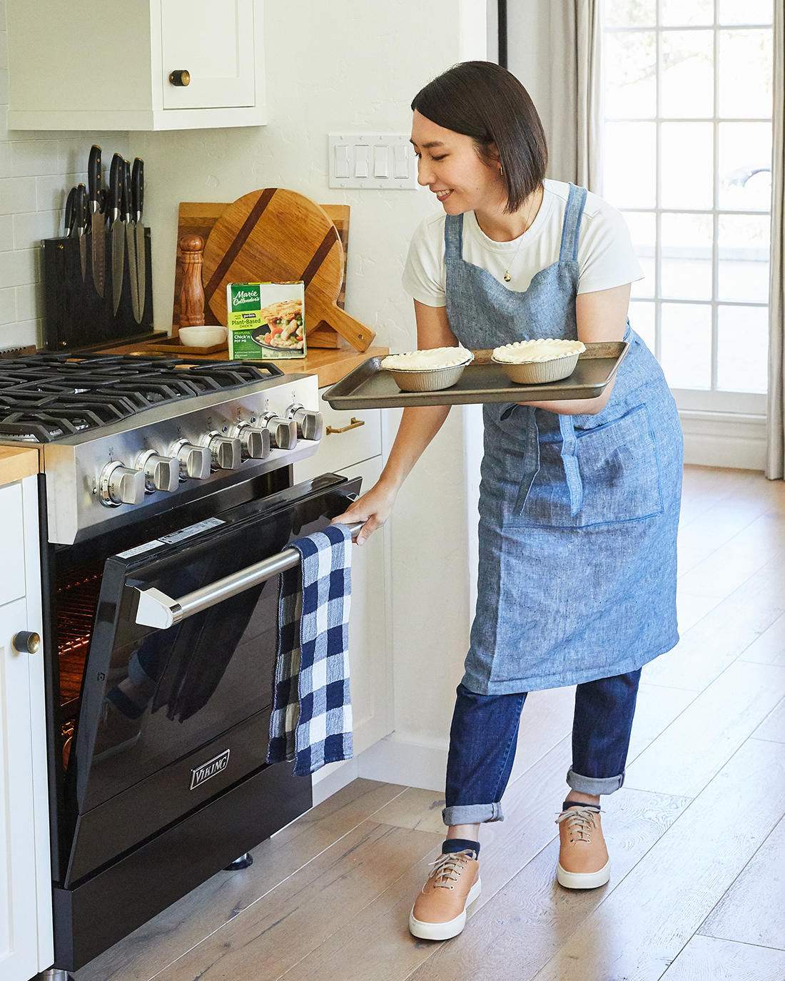 Rie placing the Marie Callendar’s plant-based chicken pot pie into the oven