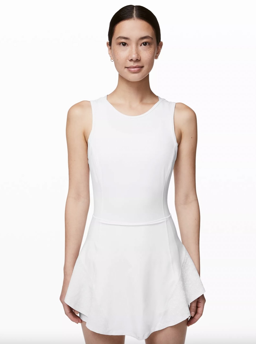 A woman wearing a white dress with a ruffle hem