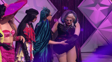 drag queen in black bodysuit crying while other drag queens comfort her