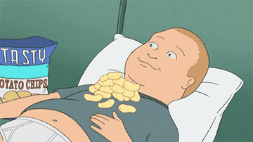 King of the Hill GIF of Bobby eating chips off his chest in bed