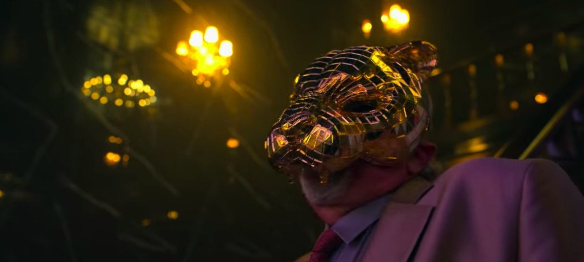 A VIP wears a gold mask