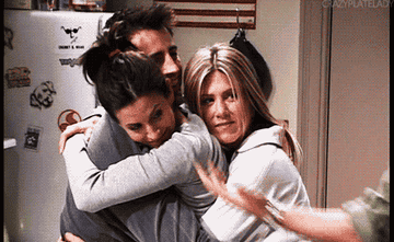 Joey, Monica, Rachel, Ross all hug in a kitchen
