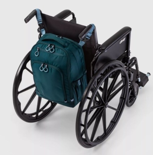 The backpack in blue on the back of a wheelchair
