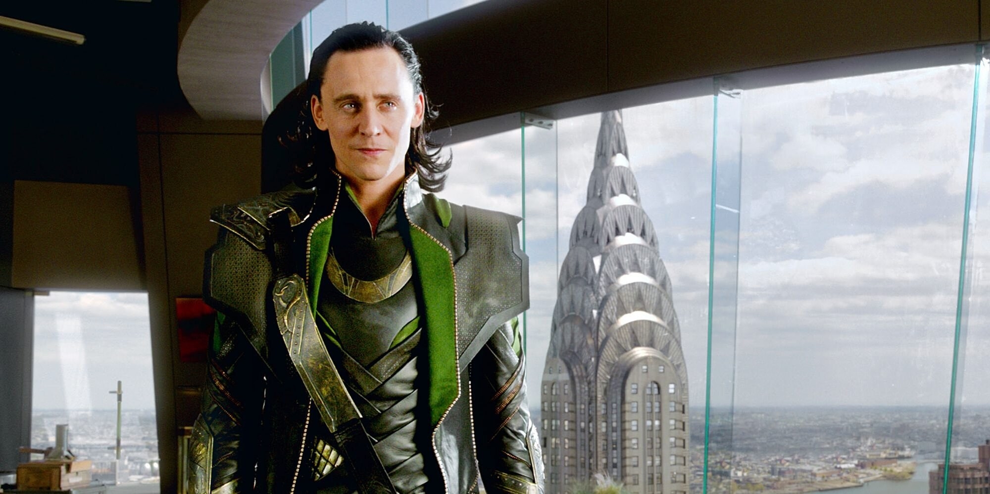 Loki stands against floor to ceiling windows above the NYC skyline