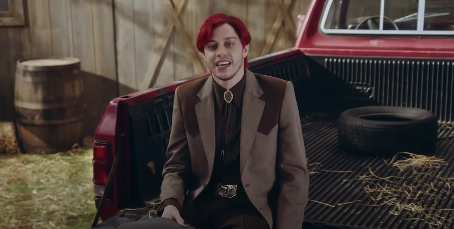 Pete with red hair sitting on the back of a truck