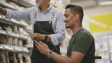 A grocery store employee assists a customer
