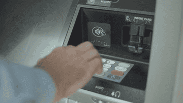 Person punches numbers into ATM