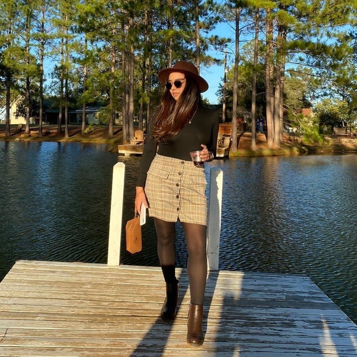 A reviewer in by a lake wearing the boots
