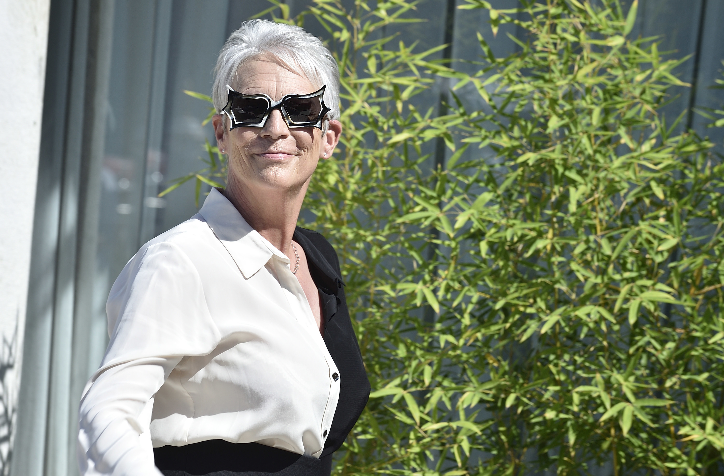 Curtis wears a two-tone dress shirt and sunglasses at a festival