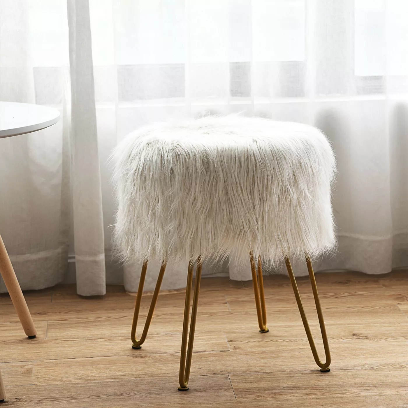 The white fur stool with gold legs