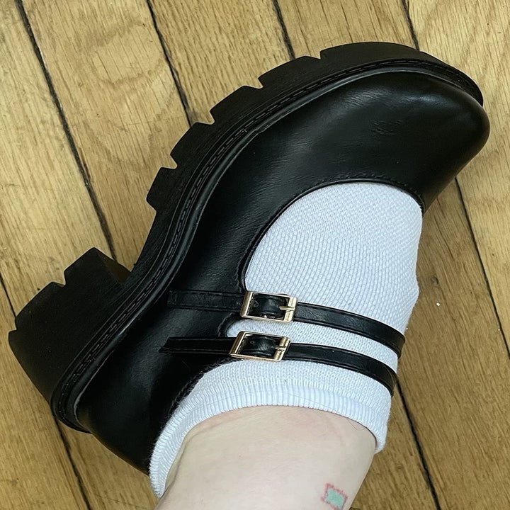 A reviewer wearing the black, double strapped mary jane platform shoes