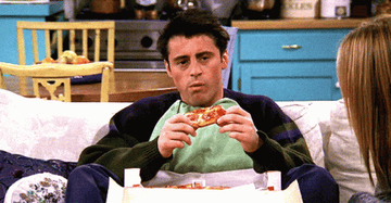 Joey from &quot;Friends&quot; eating pizza on the couch.