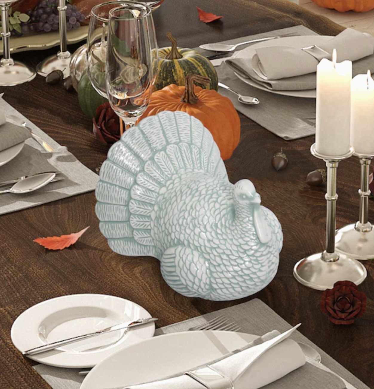 a green and white decorative ceramic turkey on a dinner table