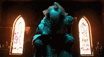 Pennywise bends down on the ground and looks up
