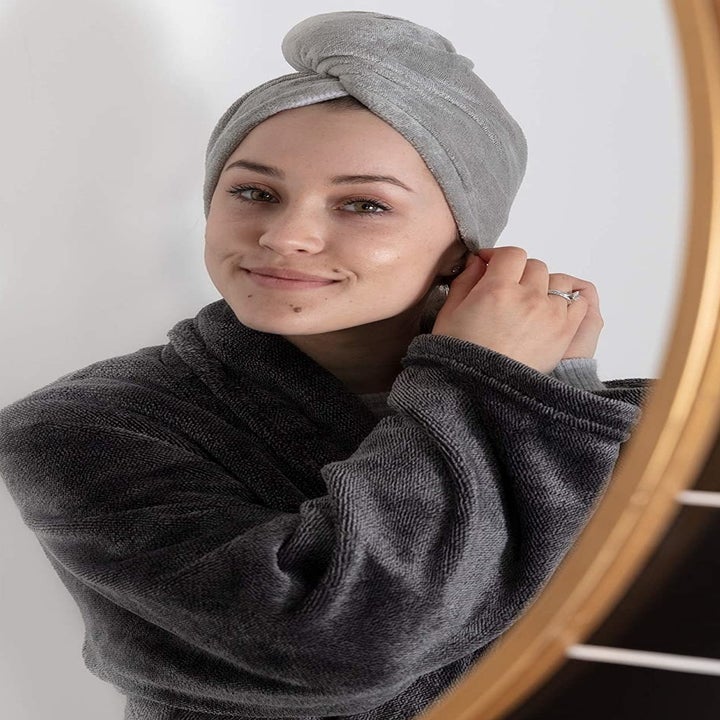A person fastening the hair towel on their head