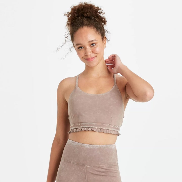 Model wearing the velvet bra in pink with ruffles at the bottom and matching velvet pink bottoms