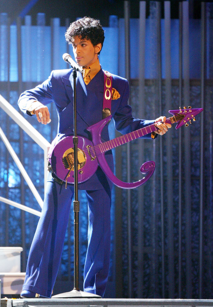 &quot;Purple Rain&quot; singer holding a guitar in the shape of the combination of the man and woman symbols