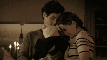gif of man and woman holding baby and smiling