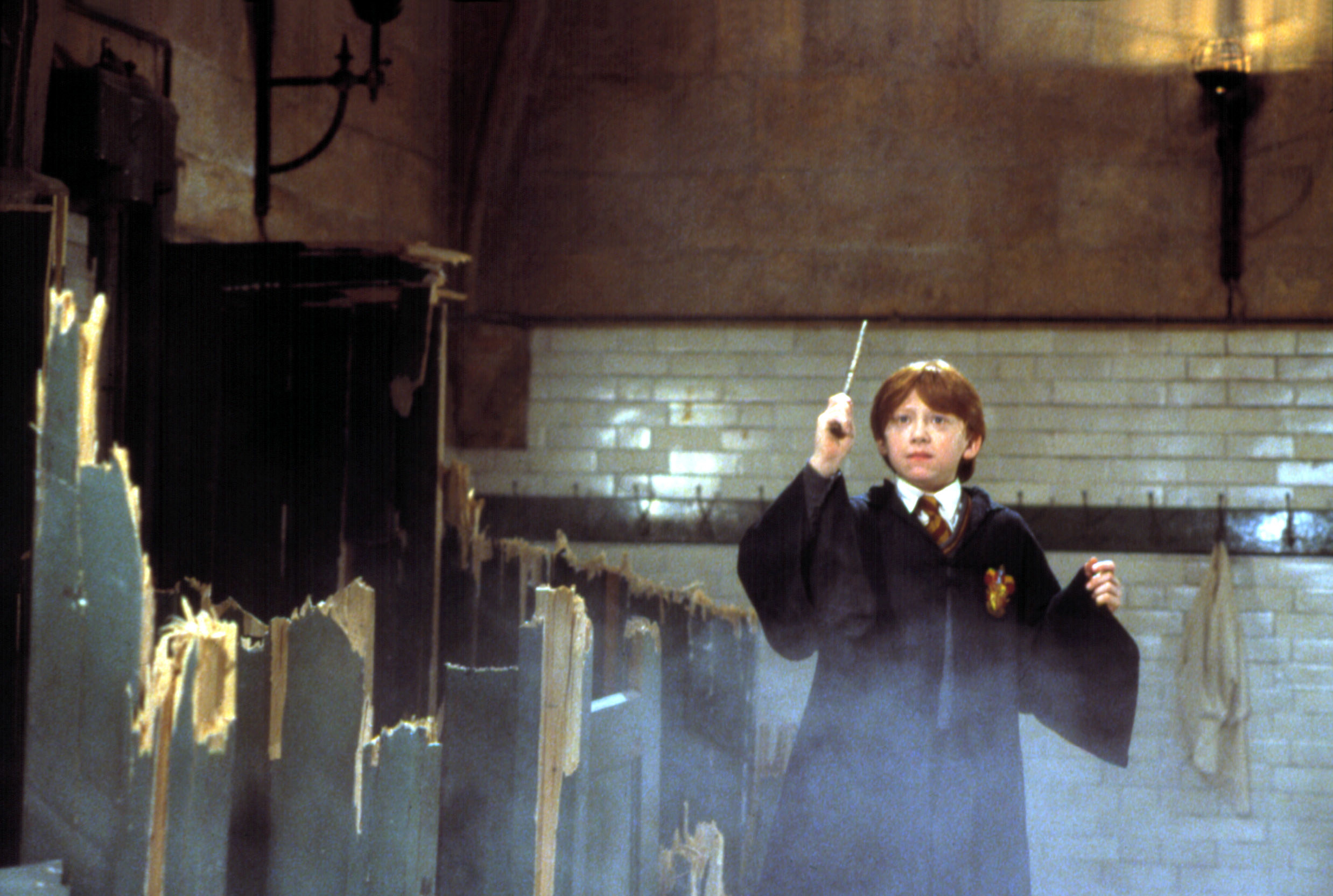 Rupert Grint points his wand in a destroyed bathroom