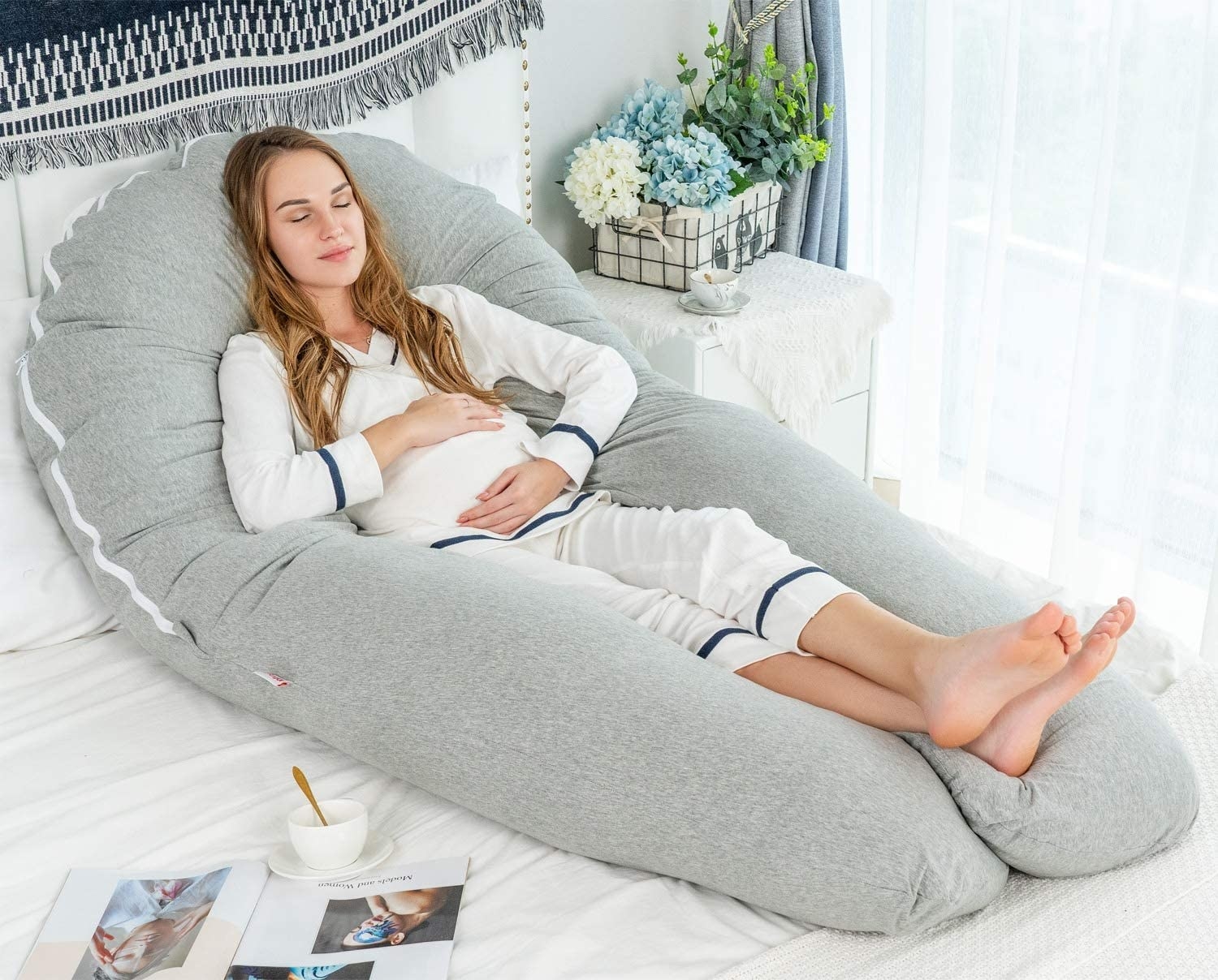 a pregnant person sitting comfortably in the body pillow