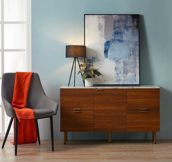 Sideboard shown in a room with a chair, artwork and accessories