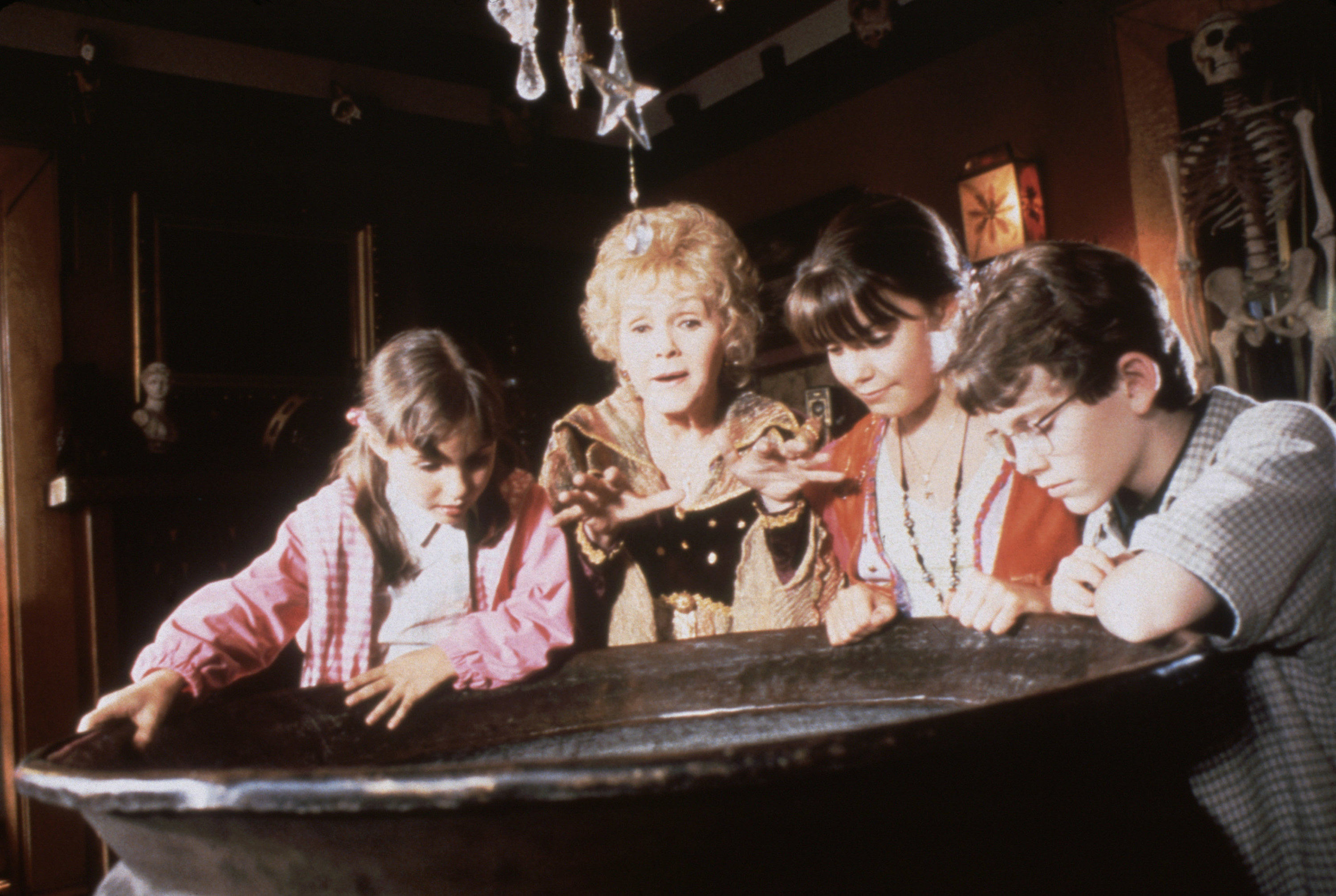 Debbie Reynolds stands around a cauldron with Emily Roeske, Kimberly J. Brown, and Joey Zimmerman