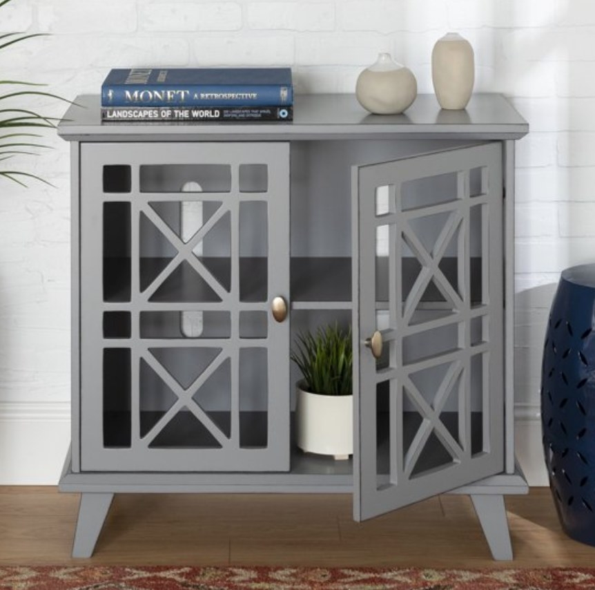 A 2 door grey accent table with 2 shelves inside