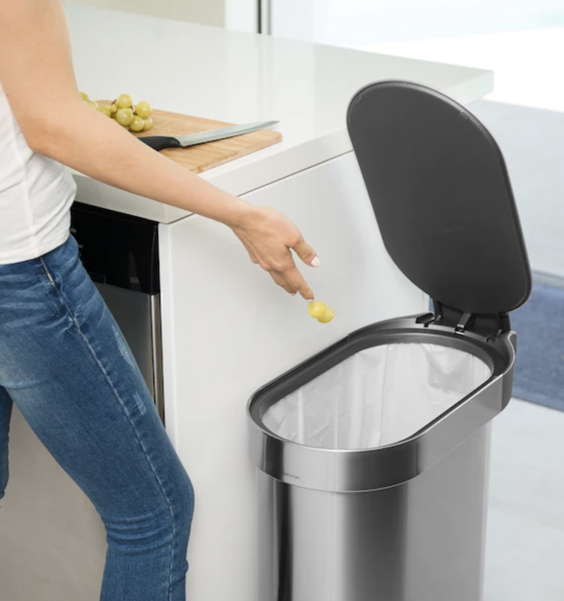 a person stepping onto a trash can to throw away scraps