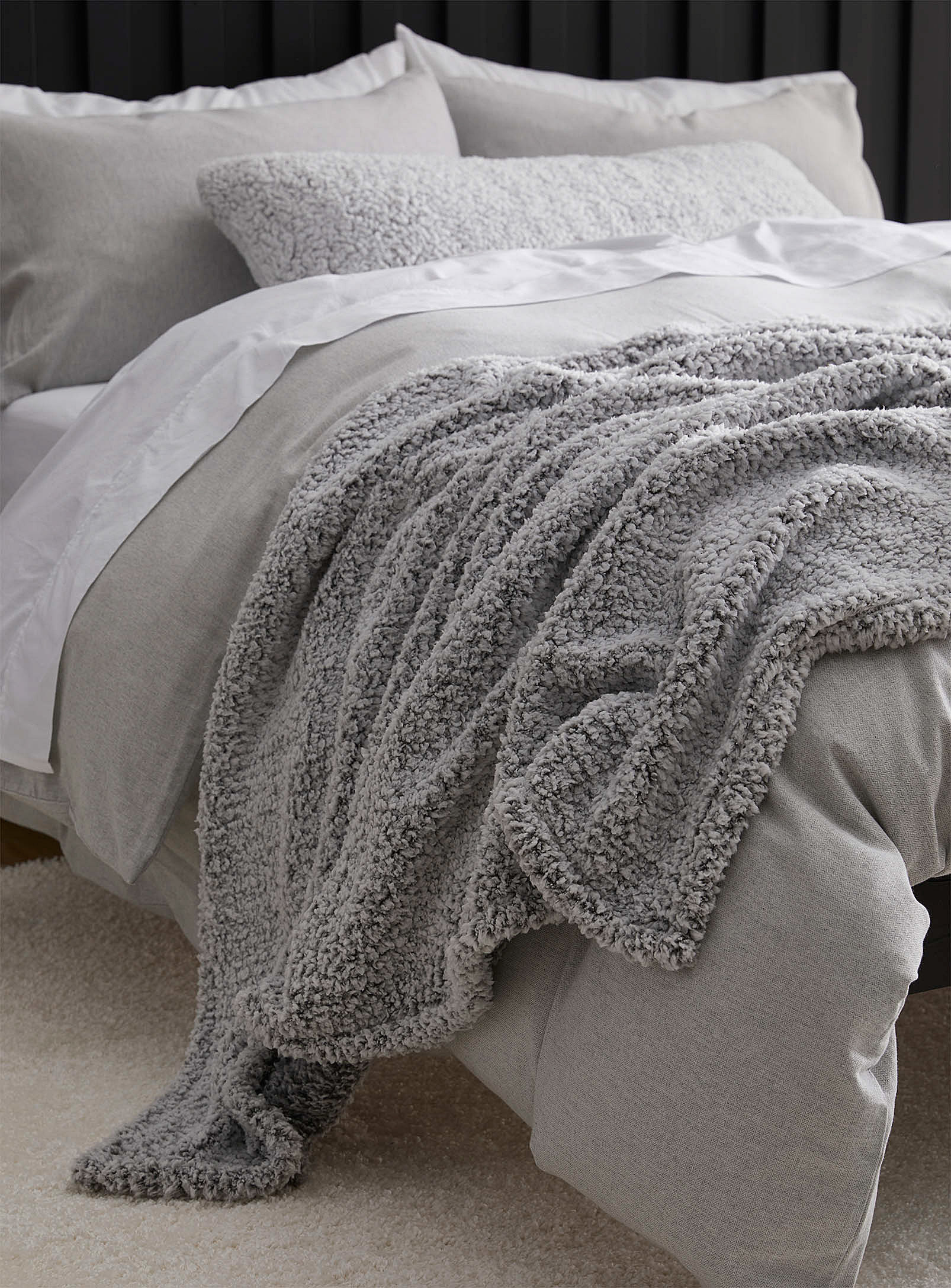 a plush sherpa blanket draped over a neatly made bed
