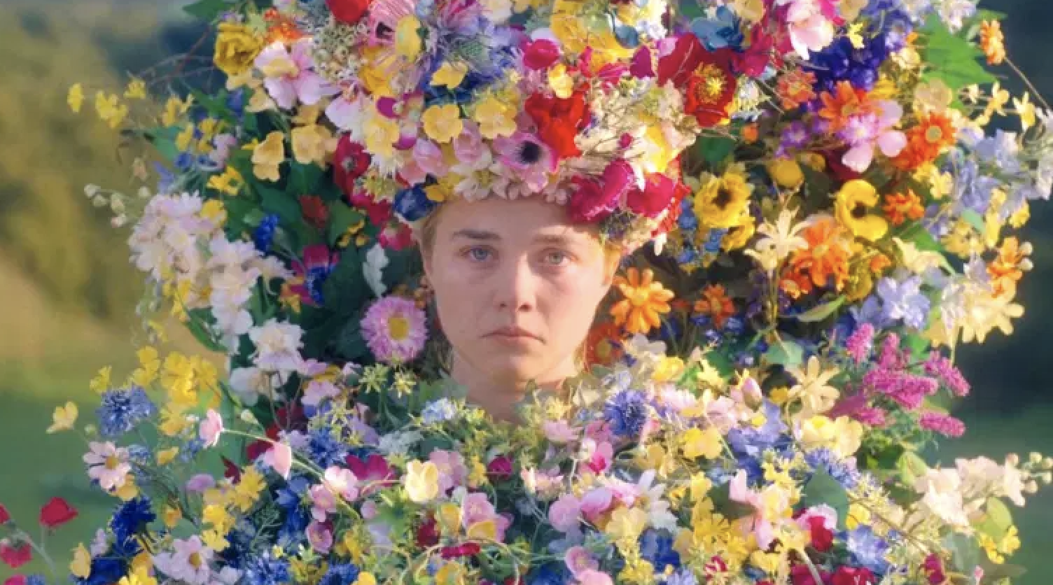 Florence Pugh frowning as she&#x27;s covered in a flower crown, wearing a flower dress, and sitting on a flower throne