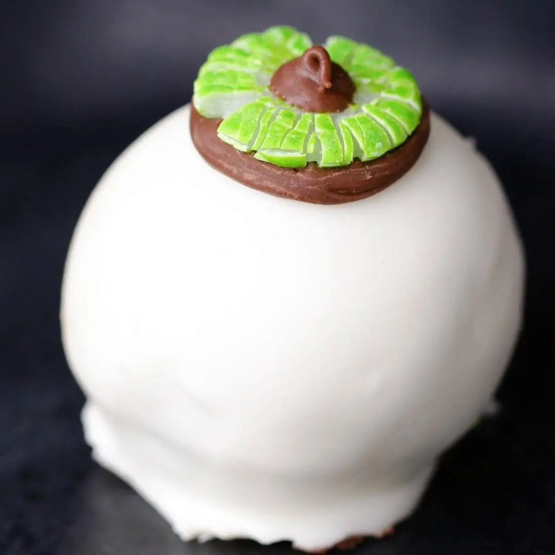 white frosting-covered brownie bite with a green decorated chocolate kiss made to resemble an eyeball