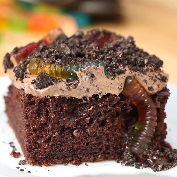 chocolate cake covered in cookie crumbles and gummy worms
