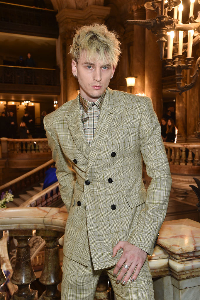 MGK posing in a suit with matching nail polish